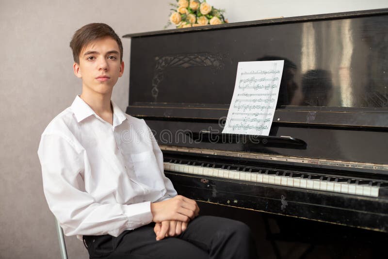 Teenage boys play piano in class or at home . student learn to play the piano. Teenage boys play piano in class or at home . student learn to play the piano