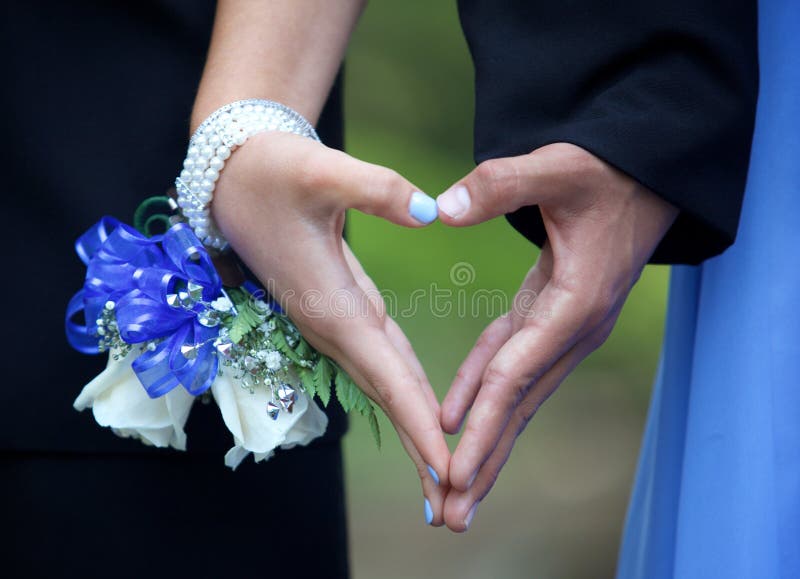 Tienerprom-Paar die Handhart tussen hen vormen royalty-vrije stock foto's Tienerprom-Paar die Handhart tussen hen vormen royalty-vrije stock foto's