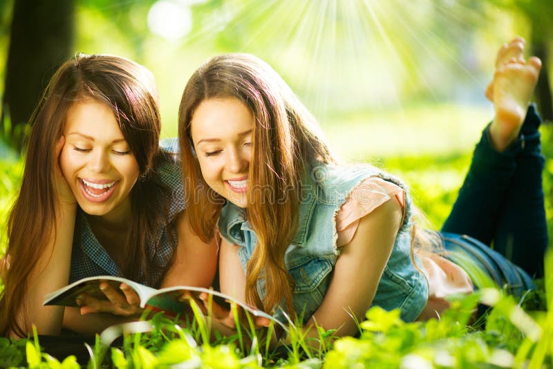Tieners die een tijdschrift in openlucht lezen royalty-vrije stock foto Tieners die een tijdschrift in openlucht lezen royalty-vrije stock foto