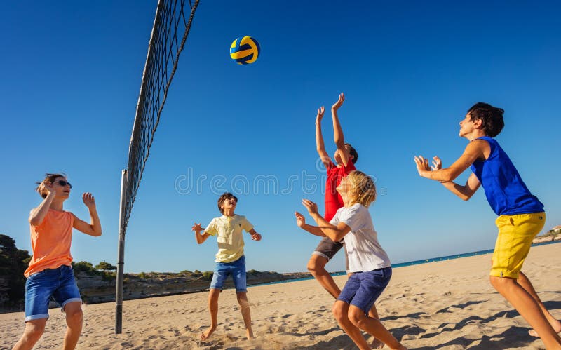 Tieners die volleyball op het strand spelen royalty-vrije stock fotografie Tieners die volleyball op het strand spelen royalty-vrije stock fotografie
