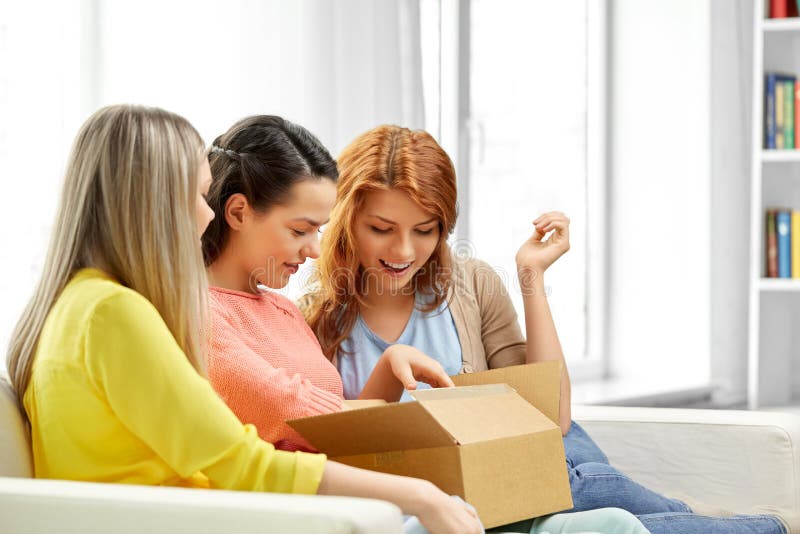Tieners of vrienden die pakketdoos openen stock afbeeldingen Tieners of vrienden die pakketdoos openen stock afbeeldingen