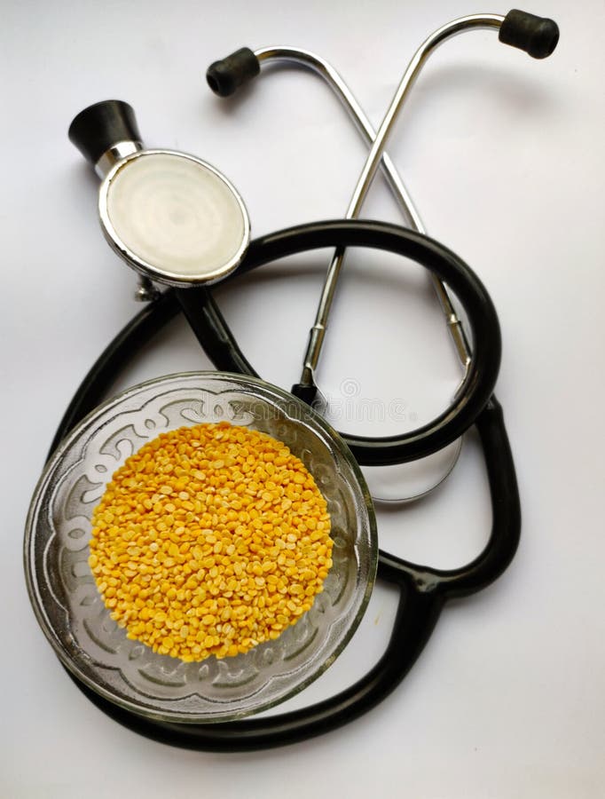 Bowl of pulses with stethoscope in white background macro view in selective focus. Bowl of pulses with stethoscope in white background macro view in selective focus