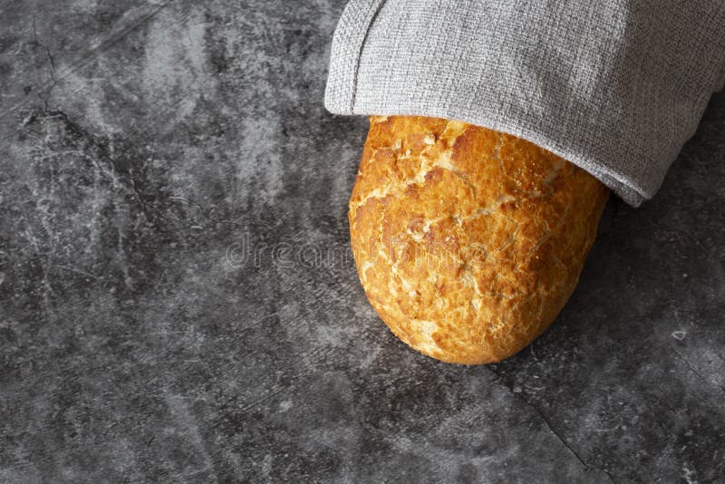 Tiger Loaf of Bread Wrapped in a Grey Tea Towel. Stock Photo Image of
