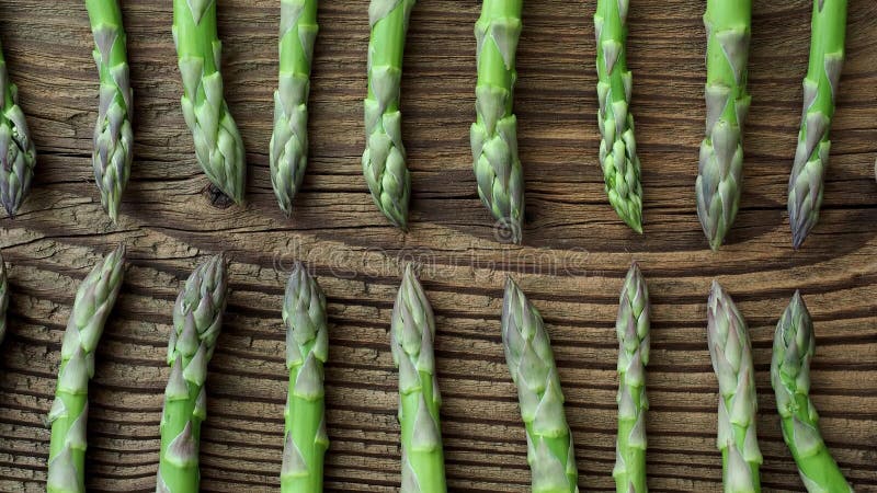 Tiges crues d'asperge Légumes verts frais de ressort sur le fond en bois