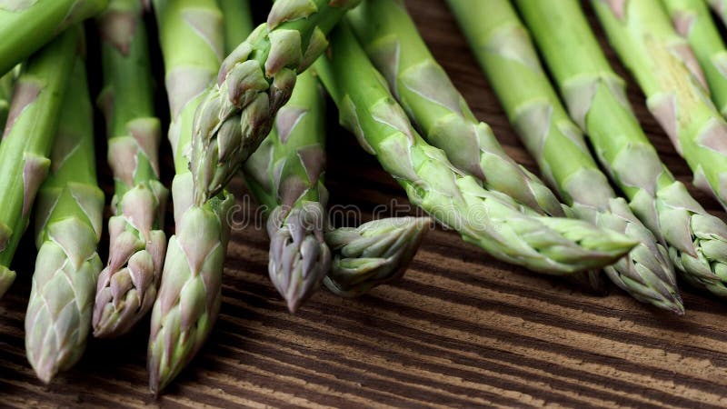 Tiges crues d'asperge Légumes verts frais de ressort sur le fond en bois