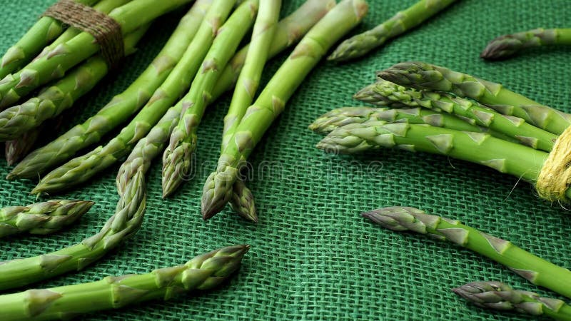 Tiges crues d'asperge Légumes verts frais de ressort sur le fond de jute