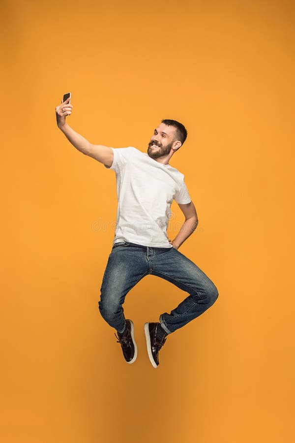 Tijd te nemen selfie Volledige lengte van de knappe jonge mens die selfie terwijl het springen nemen stock foto Tijd te nemen selfie Volledige lengte van de knappe jonge mens die selfie terwijl het springen nemen stock foto
