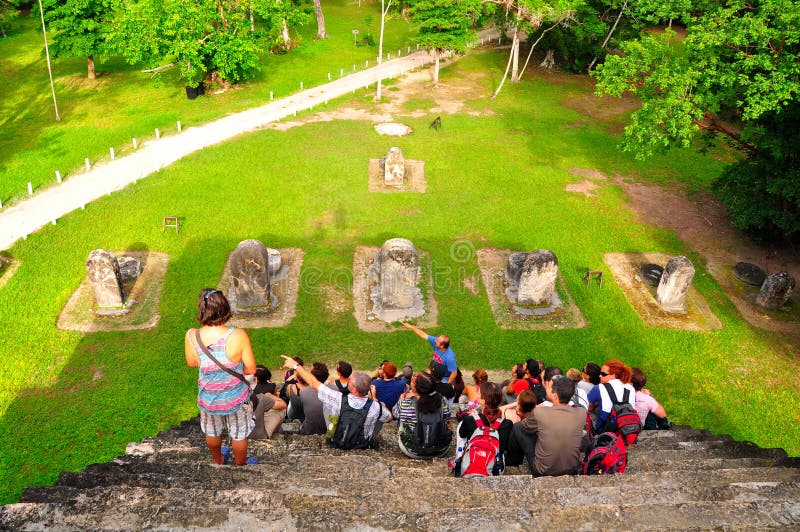 A guided group of tourists at the Ancient Maya temple in Tikal, Guatemala. A guided group of tourists at the Ancient Maya temple in Tikal, Guatemala