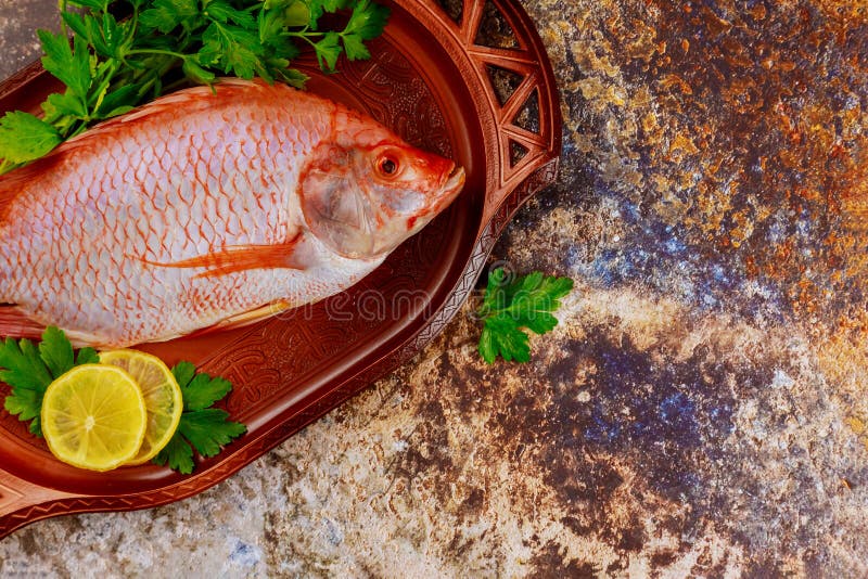Tilapia cruda rosa con hierbas y limón imágenes de archivo libres de regalías