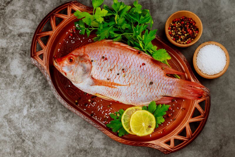 Tilapia entera fresca con especias y limón. vista superior imágenes de archivo libres de regalías