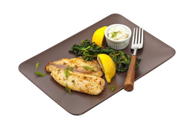 Tilapia med Sauteed spenat arkivbilder Tilapia med Sauteed spenat arkivbilder