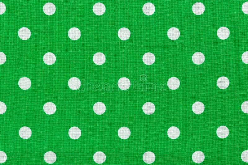 Tile pattern with white polka dots on green background.