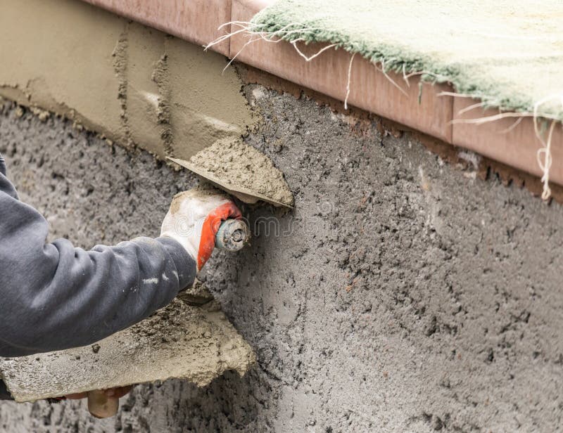 Tile Worker Applying Cement with Trowel at Pool Construction Site Stock