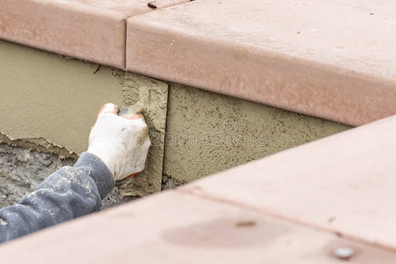 Tile Worker Applying Cement with Trowel at Pool Construction Site Stock