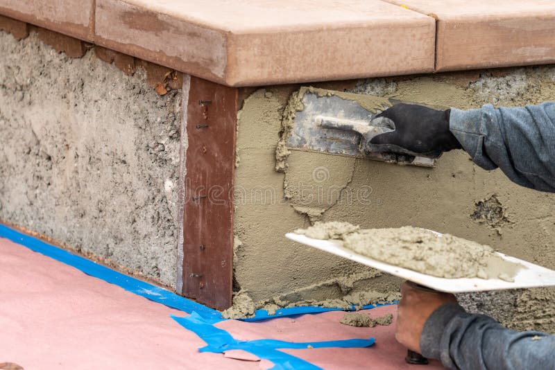 Tile Worker Applying Cement with Trowel at Pool Construction Site Stock