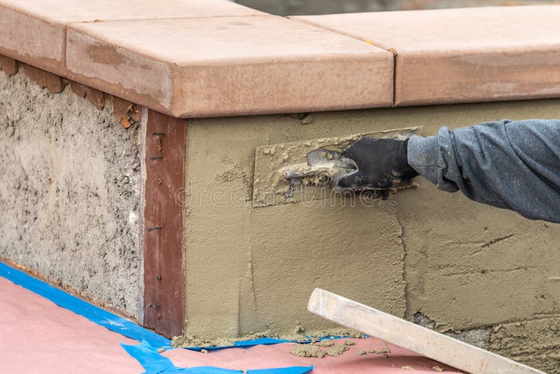 Tile Worker Applying Cement with Trowel at Pool Construction Site Stock