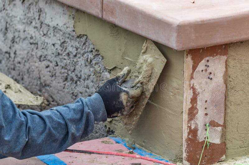 Tile Worker Applying Cement with Trowel at Pool Construction Site Stock