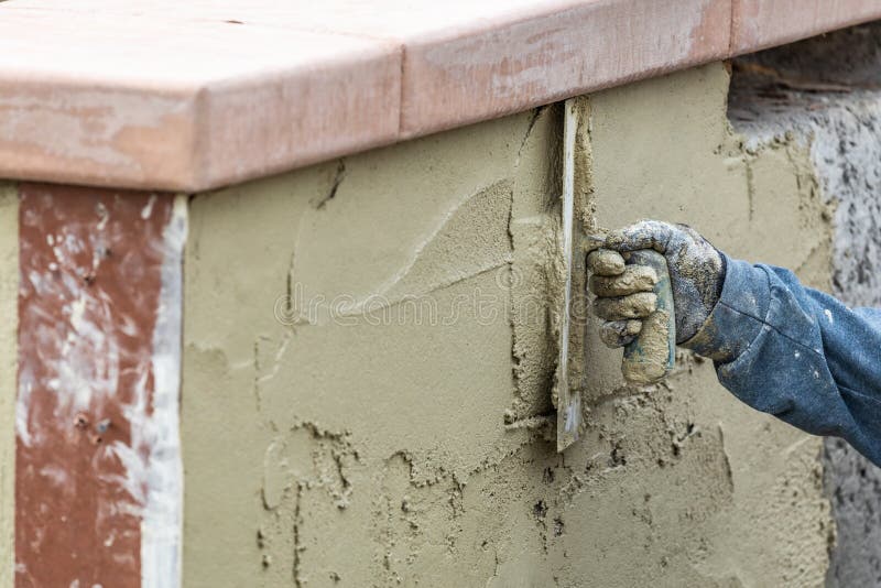 Tile Worker Applying Cement with Trowel at Pool Construction Site Stock