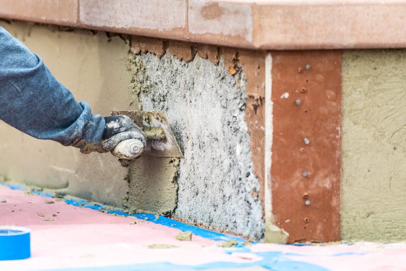 Tile Worker Applying Cement with Trowel at Pool Construction Site Stock