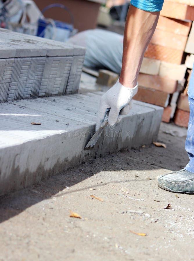 Tiler Processes the Surface for Laying the Stone Tiles on the Steps in the Repair of the Office