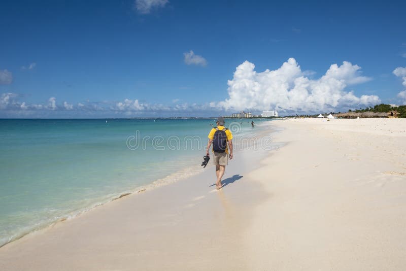 Tillbaka sikt av en man som går på en karibisk strand 3 royaltyfri bild Tillbaka sikt av en man som går på en karibisk strand 3 royaltyfri bild