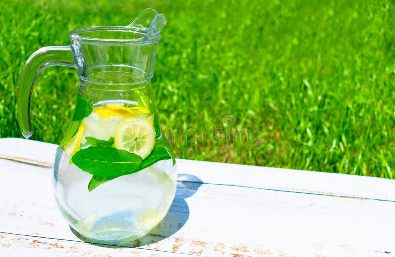 Tillbringare med lemonad från citronen och mats med is på en bakgrund av grönt gräs begreppet av l?sk N?rbild royaltyfri bild Tillbringare med lemonad från citronen och mats med is på en bakgrund av grönt gräs begreppet av l?sk N?rbild royaltyfri bild