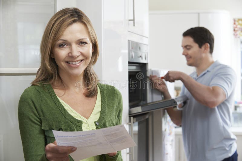 Portrait Of Satisfied Female Customer With Oven Repair Bill. Portrait Of Satisfied Female Customer With Oven Repair Bill