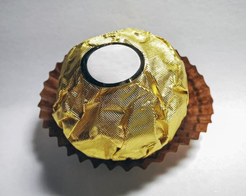 Tillredning av chokladkonfektyrer av guld-folie arkivfoto