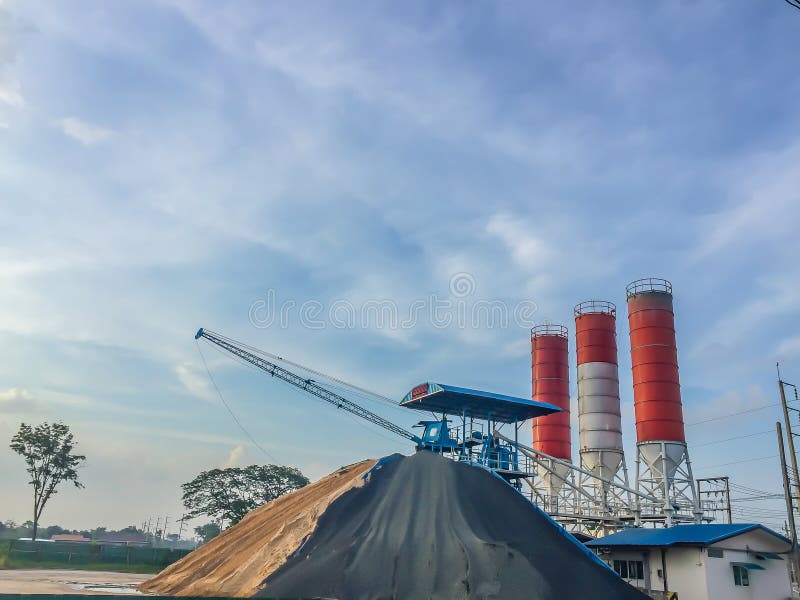 Cement concrete mixing production factory with dramatic sky background. Concrete batching plant at construction site. Cement concrete mixing production factory with dramatic sky background. Concrete batching plant at construction site.