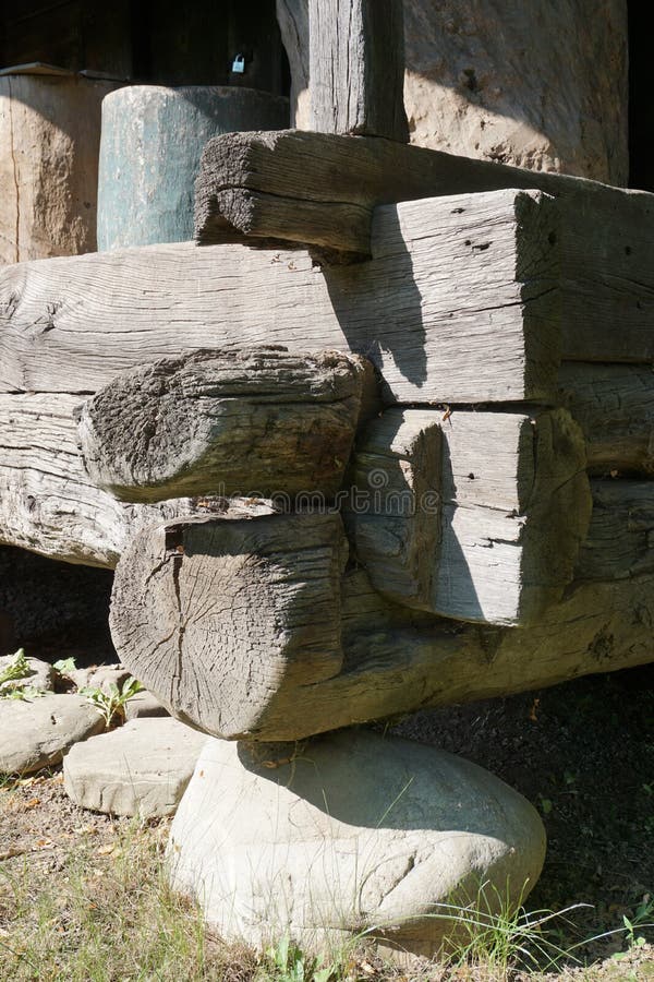 Timber footing beams placed on stone supports, corner detail to rural house stock image Timber footing beams placed on stone supports, corner detail to rural house stock image