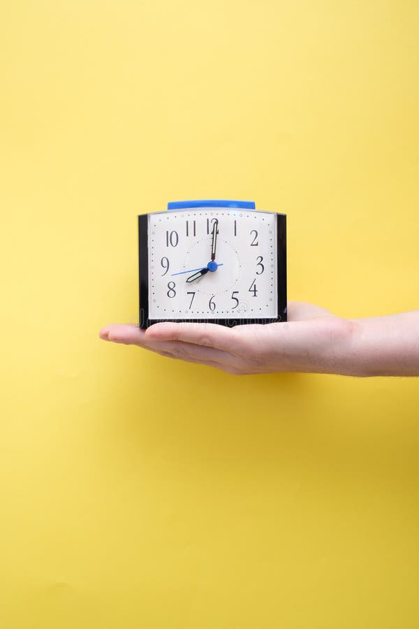 Hand Holding Alarm Clock on Yellow Background Stock Photo Image of