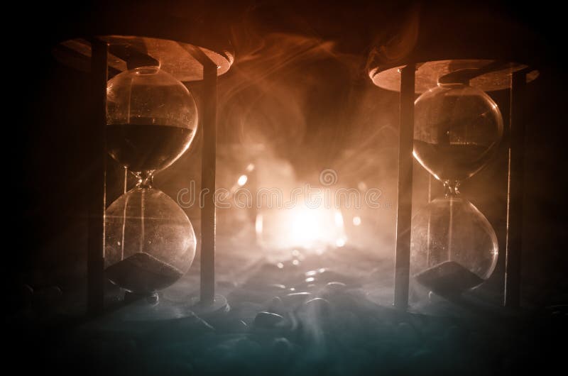 Time concept. Sand passing through the glass bulbs of an hourglass measuring the passing time as it counts down to a deadline. Sil