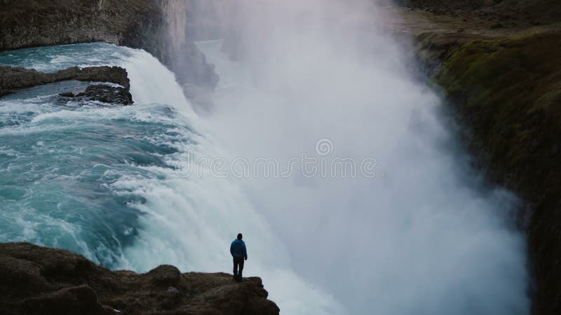 Time lapse of landscape of the Gullfoss waterfall in Iceland and man standing on edge of the cliff, enjoying the view.