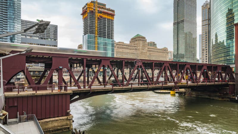 Time-lapse of train, car traffic transportation on railway bridge road, boat on river, and building construction in business distr