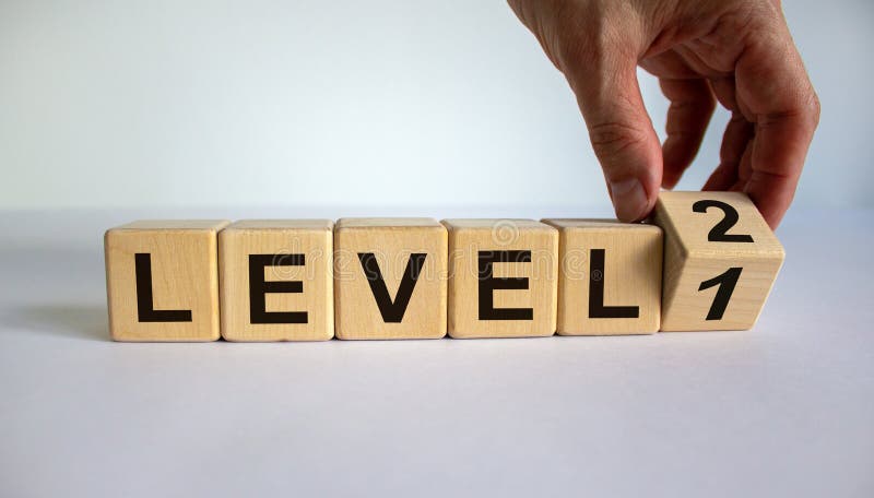 Time for Level 2. Hand is turning a cube and changes the word `level 1` to `level 2`. Beautiful white background. Business con