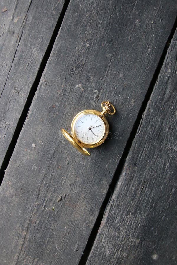 Time Management Idea. Golden Pocket Watch on a Vintage Table. Stock