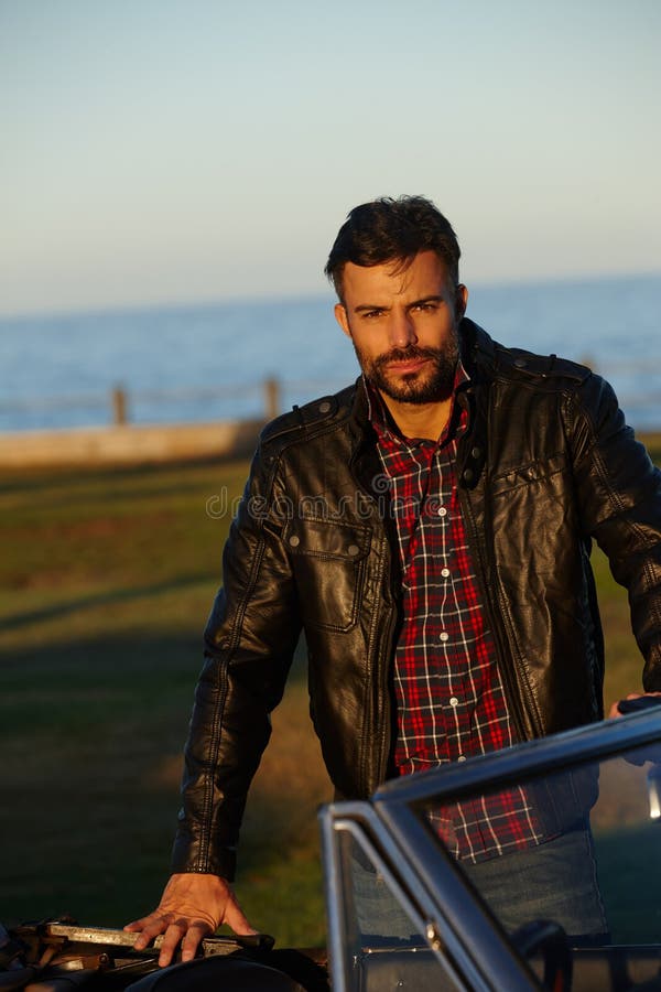 Time To Hit the Road. a Handsome Young Man Leaning on His Car. Stock