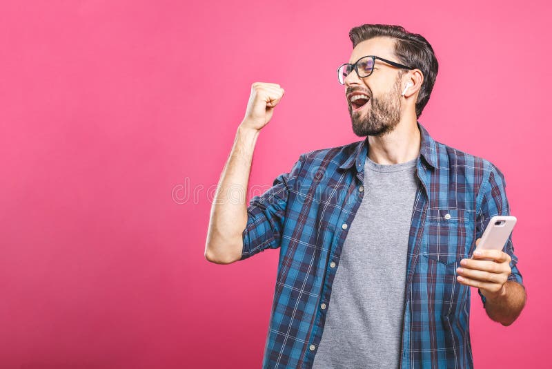 Time to relax. Handsome young man in headphones keeping eyes closed while dancing. Over pink background. Isolated