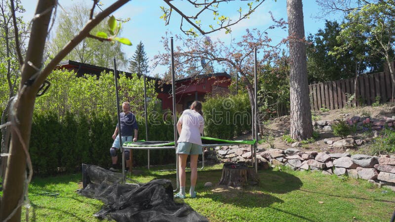 Timelapse de famille avec deux enfants assemblant trampoline clips vidéos