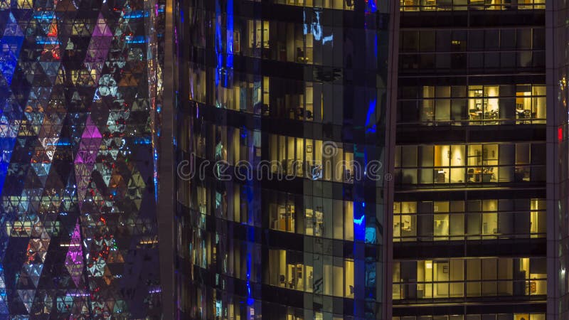 Timelapse de Windows du bâtiment à plusiers étages de l'éclairage en verre et en acier et des travailleurs de bureau en dedans banque de vidéos