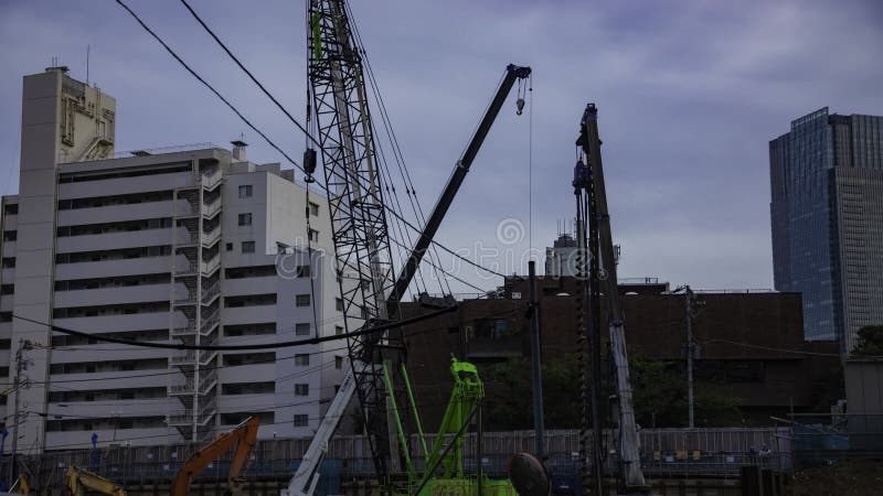 A timelapse of moving crane at the under construction in Tokyo tilt stock footage
