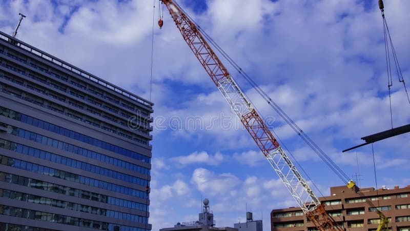 A timelapse of moving cranes at the under construction in Tokyo tilt stock footage