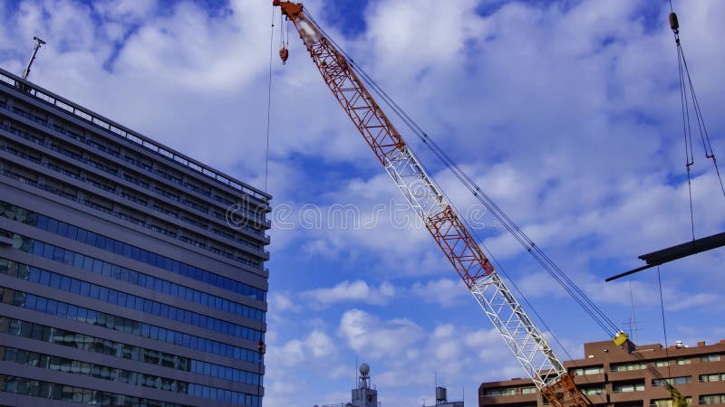 A timelapse of moving cranes at the under construction in Tokyo tilt stock video footage