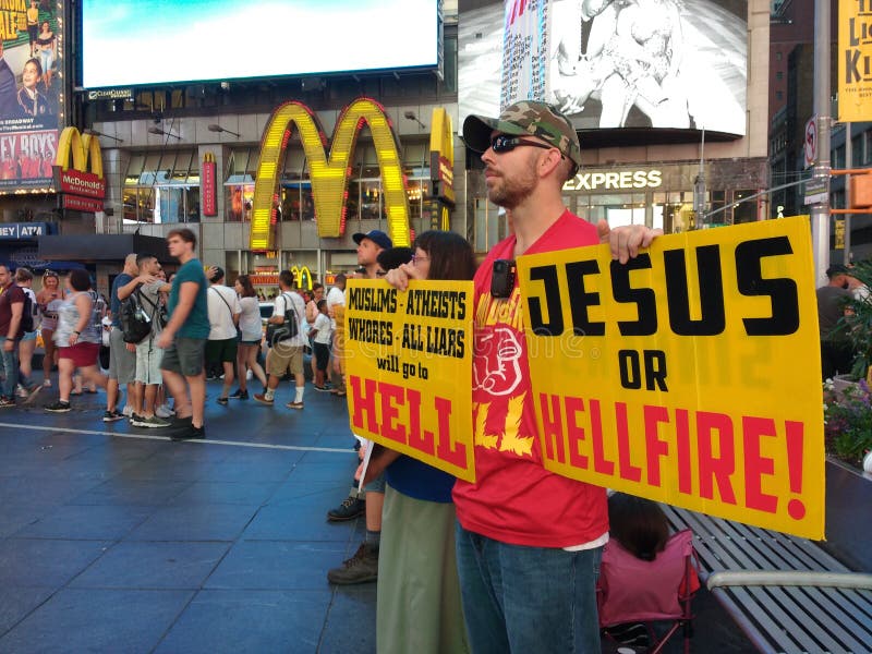 In Times Square, a man holds a couple of cautionary signs. One of the signs declares, `Jesus Or Hellfire!` This photo was taken in New York City on July 2nd 2018. In Times Square, a man holds a couple of cautionary signs. One of the signs declares, `Jesus Or Hellfire!` This photo was taken in New York City on July 2nd 2018.