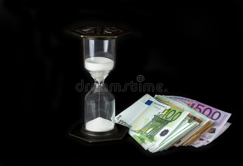 Timglas och pappers- pengar Tid är pengarbegreppet fotografering för bildbyråer