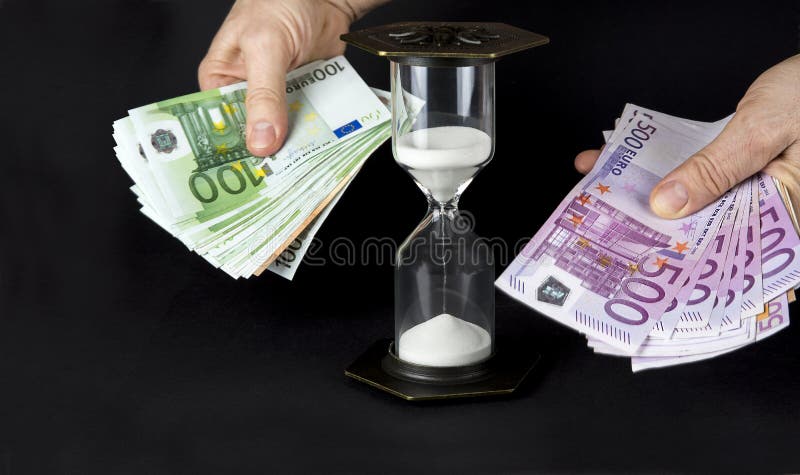 Timglas och papperspengar. Konceptet: tid är pengar arkivbild