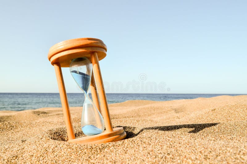 Timglasklocka på sandstranden royaltyfri foto