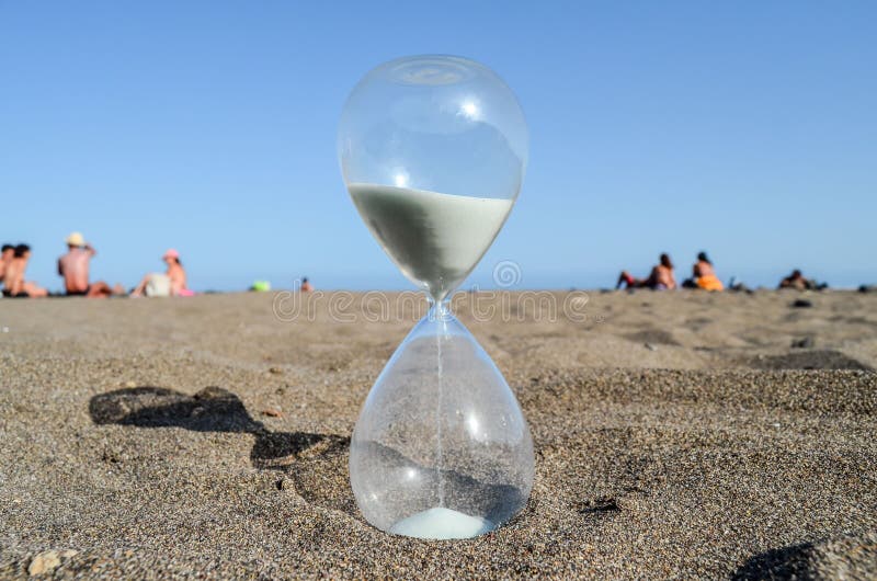 Timglasklocka på sandstranden royaltyfri foto