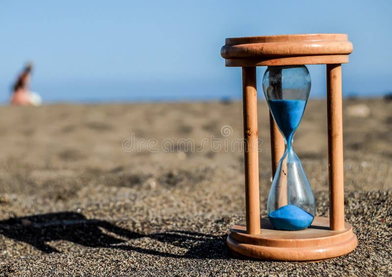 Timglasklocka på sandstranden royaltyfri foto