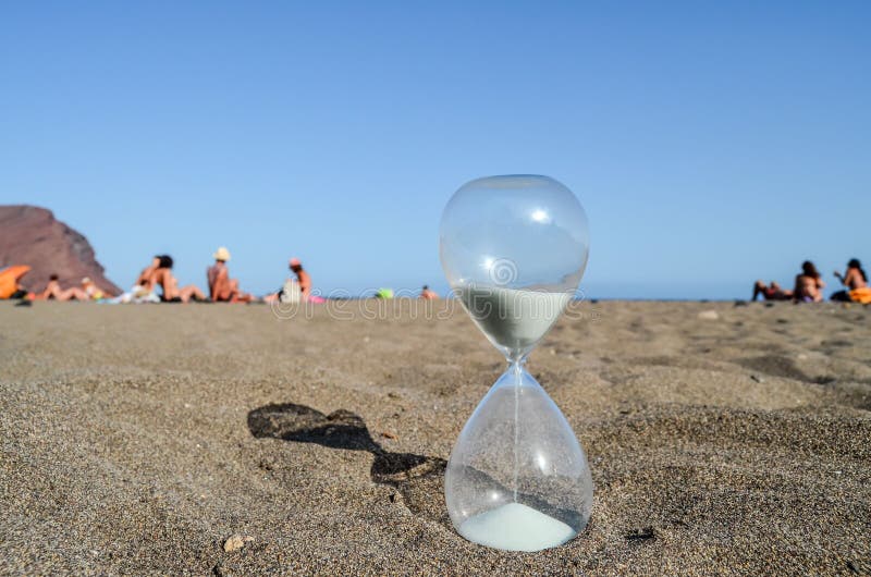 Timglasklocka på sandstranden royaltyfria bilder